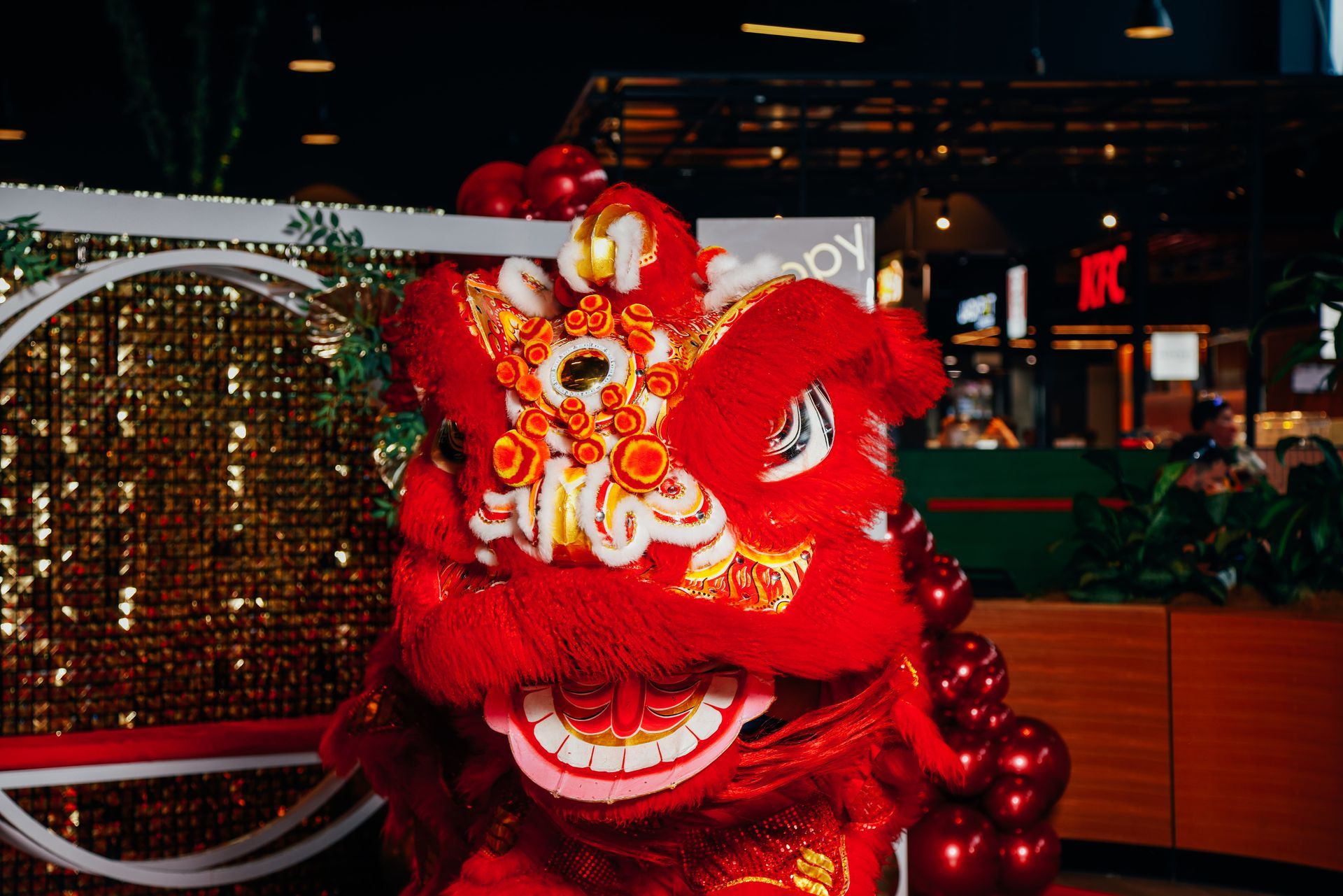 A red lion costume is sitting in front of a restaurant.