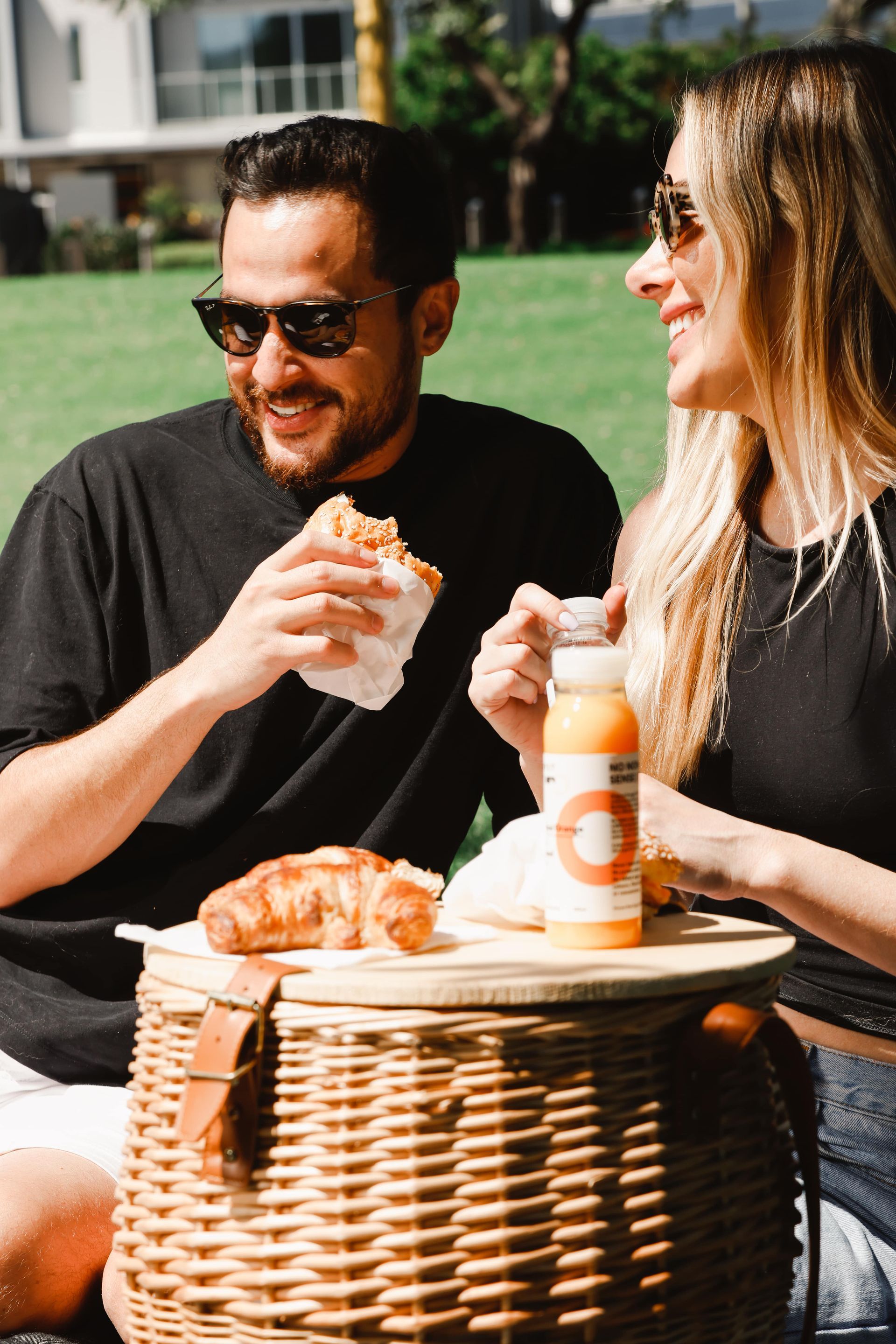 A man and a woman are sitting at a table eating food.