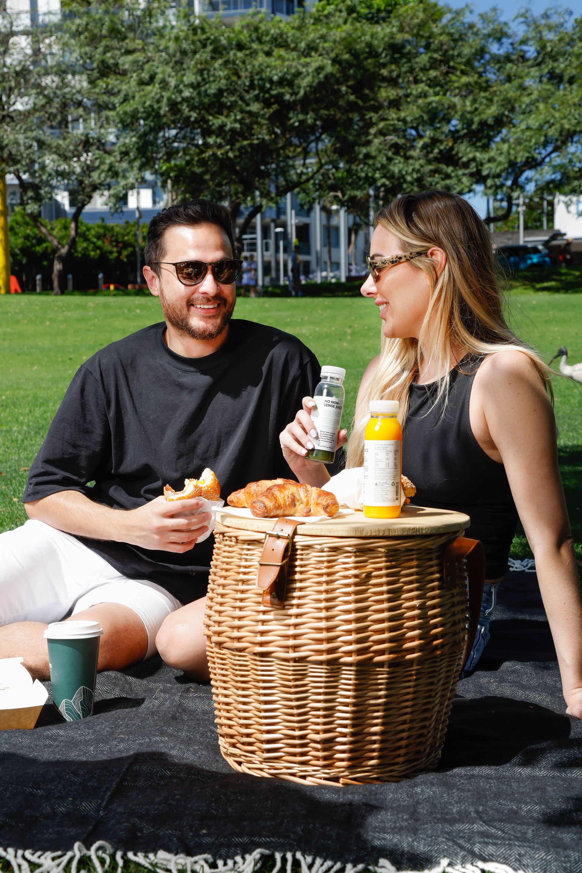 A man and a woman are having a picnic in a park.