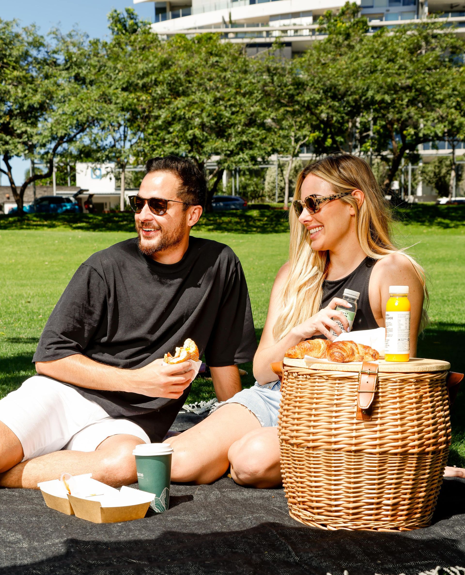 A man and a woman are having a picnic in a park.