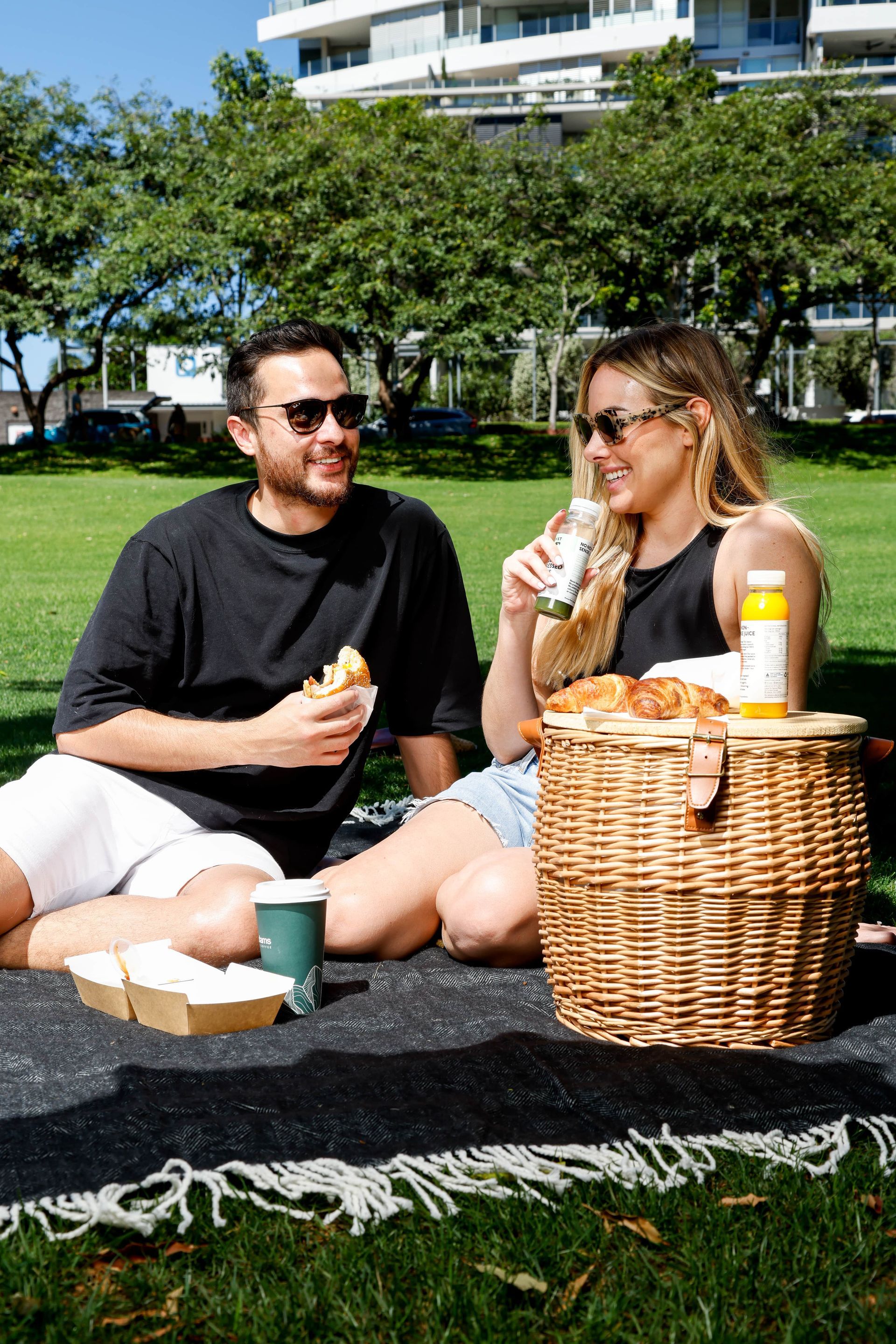 A man and a woman are having a picnic in a park.