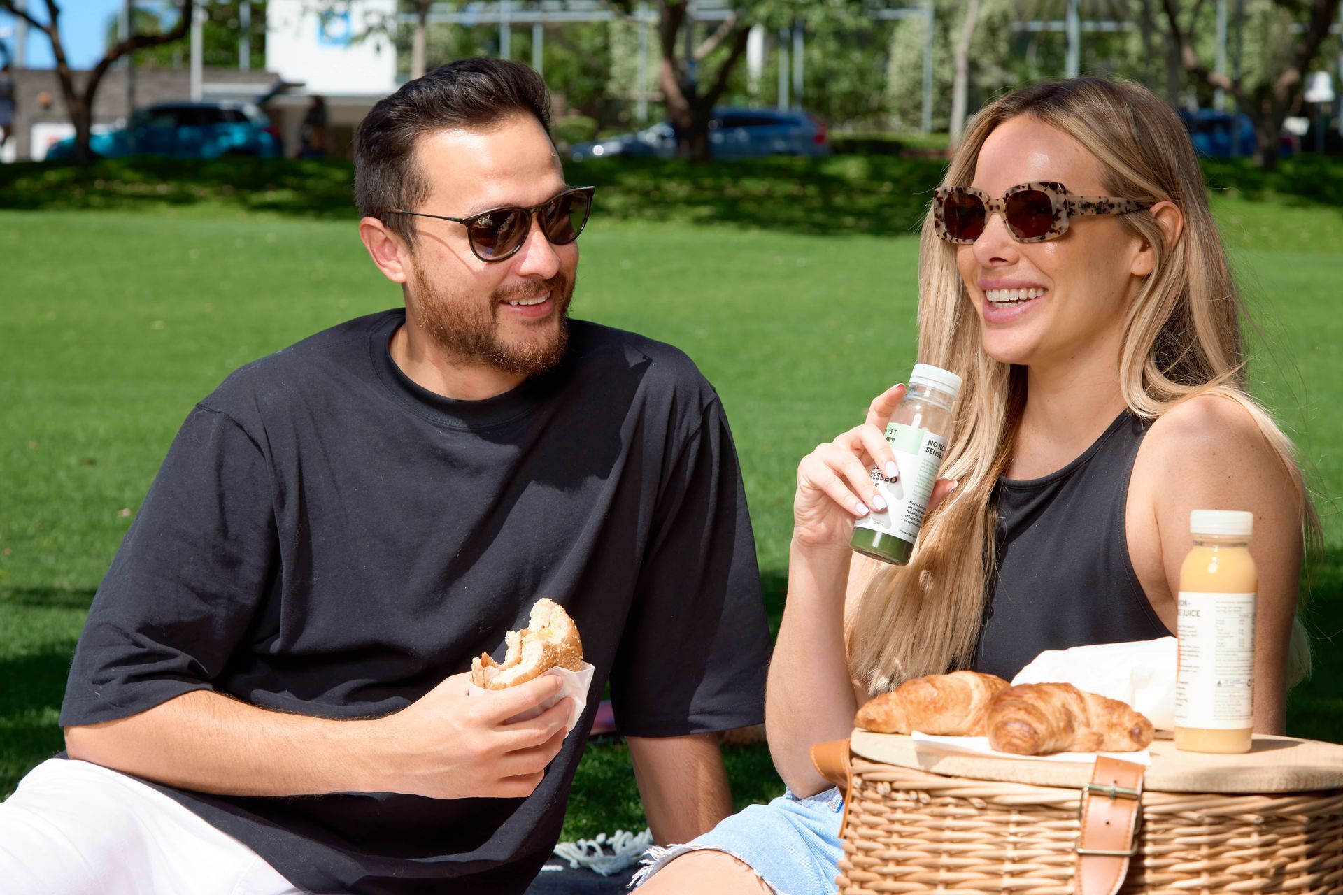 A man and a woman are having a picnic in a park.