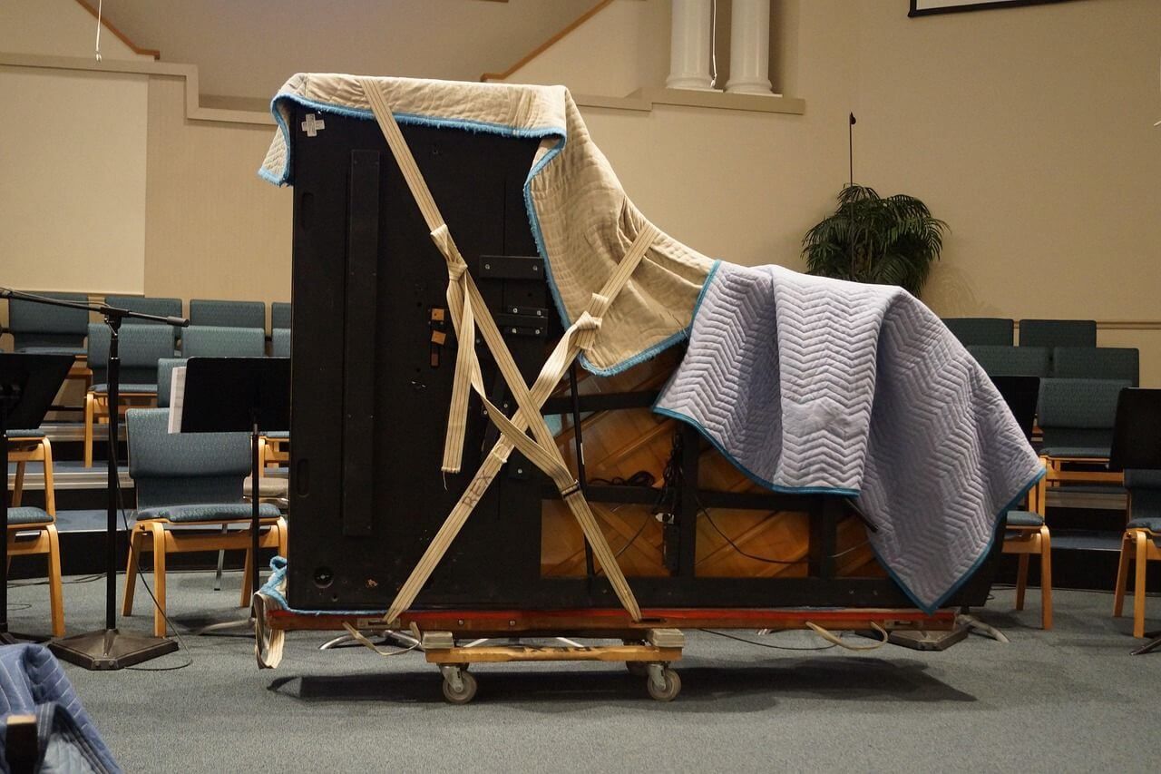piano being mounted on a trolley