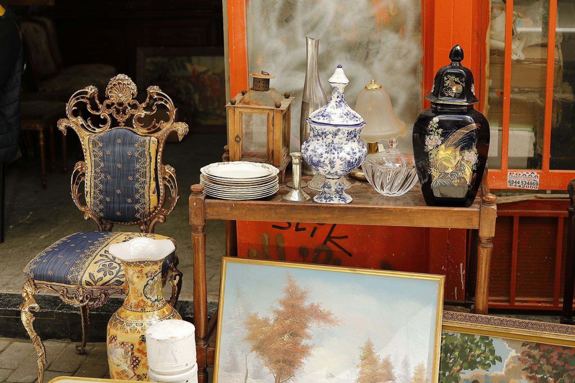 antiques a blue decorated chair and a painting of red trees all organized together