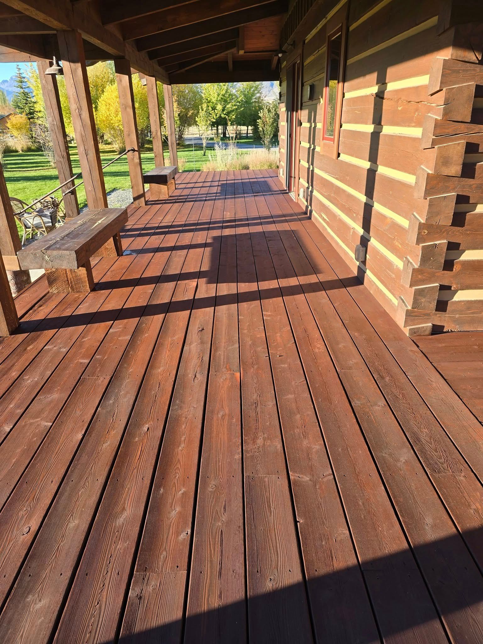Wooden porch with a bench, attached to a log cabin.