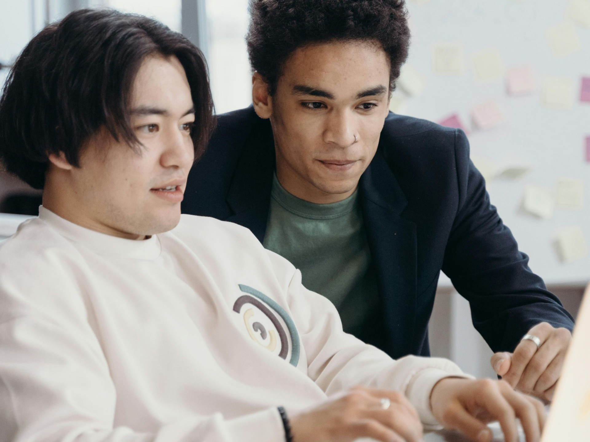 To men working at a computer together.
