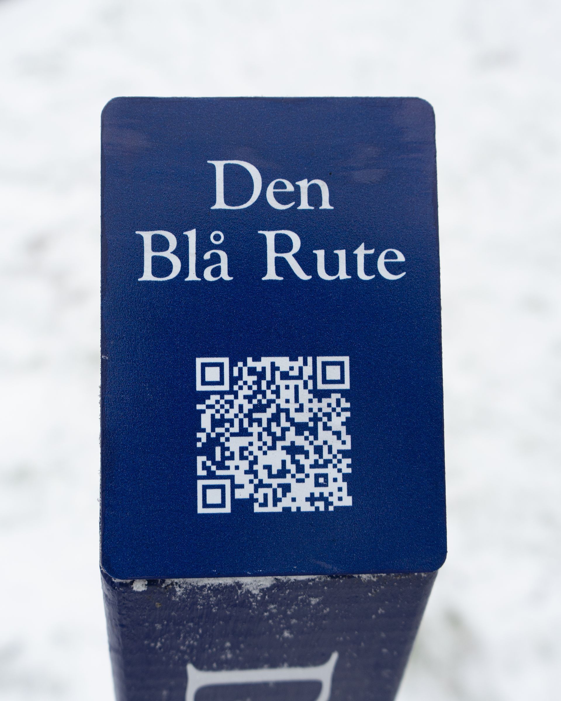 et blåt skilt, hvor der står den blå rute med en qr-kode på