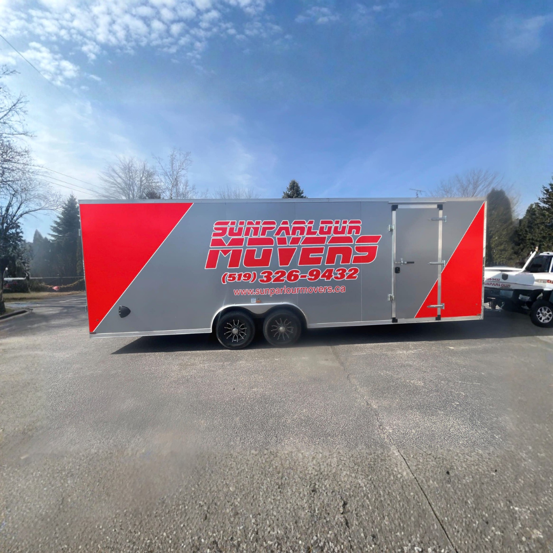 A silver moving trailer with red diagonal accents, branded with