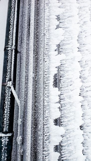 Frost-covered water pipe in winter