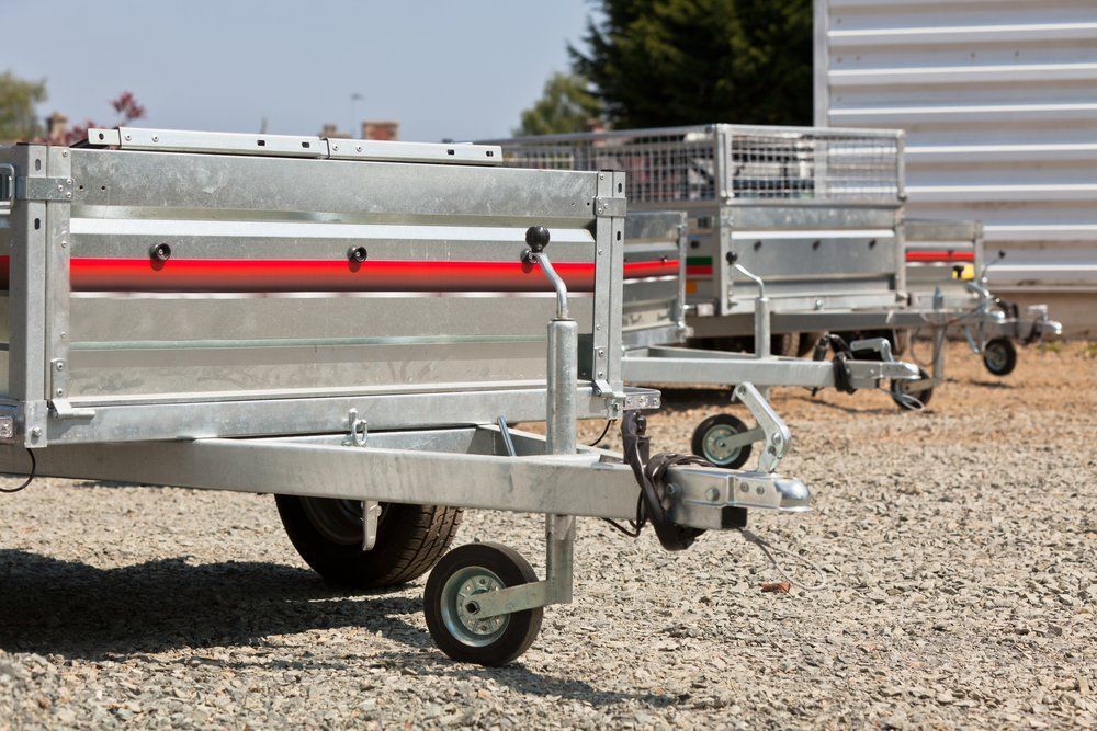 A Row of Trailers Are Parked in A Gravel Lot — Emu Park Automotive and Tyre Service in Emu Park, QLD