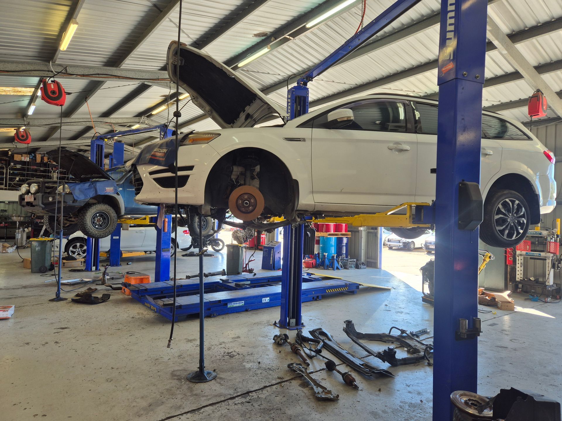White SUV Lifted on a Garage Hoist With Hood Open — Emu Park Automotive and Tyre Service in Emu Park, QLD