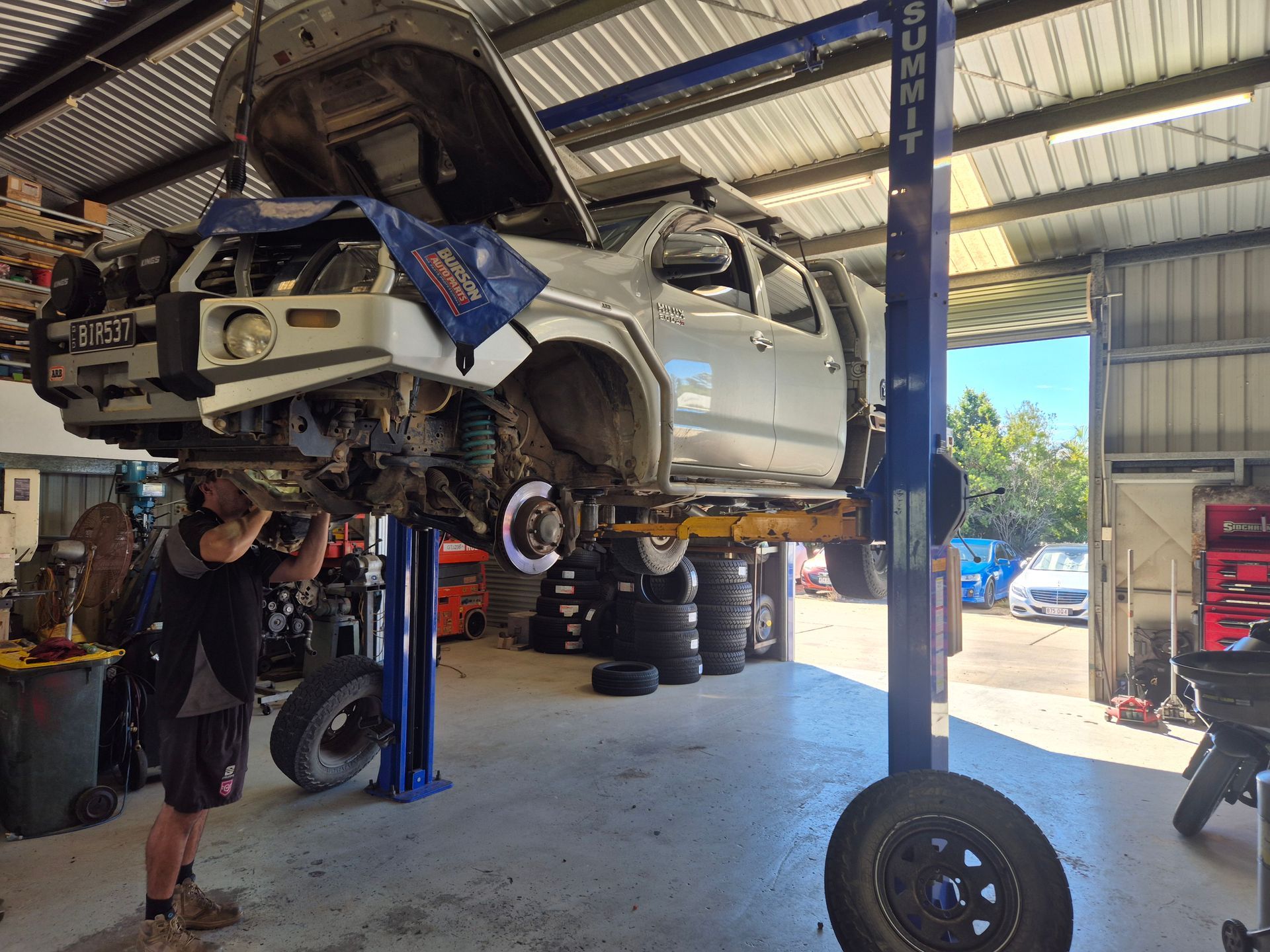 Silver Pickup Truck Lifted on a Hoist in an Auto Shop — Emu Park Automotive and Tyre Service in Emu Park, QLD