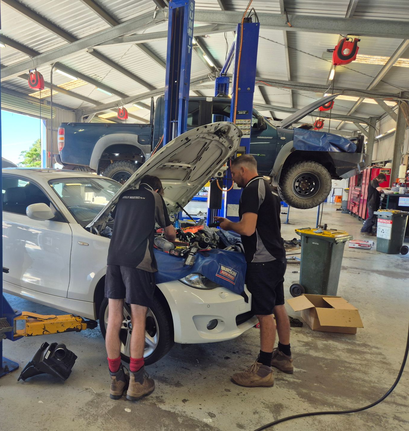 Two Mechanics Working on a White Car With the Hood Raised — Emu Park Automotive and Tyre Service in Emu Park, QLD