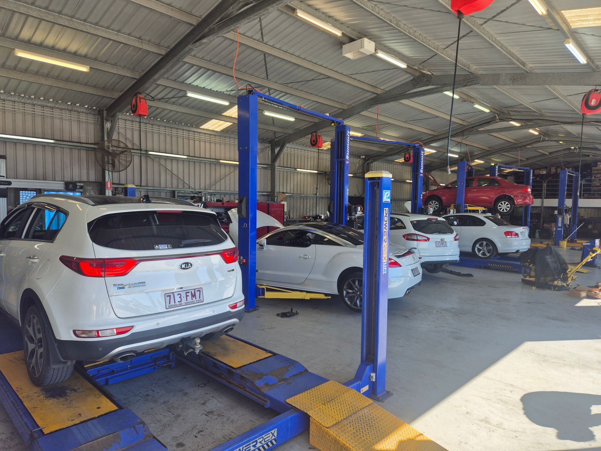 Car Repair Shop With Several Cars on Lifts and a White SUV — Emu Park Automotive and Tyre Service in Emu Park, QLD