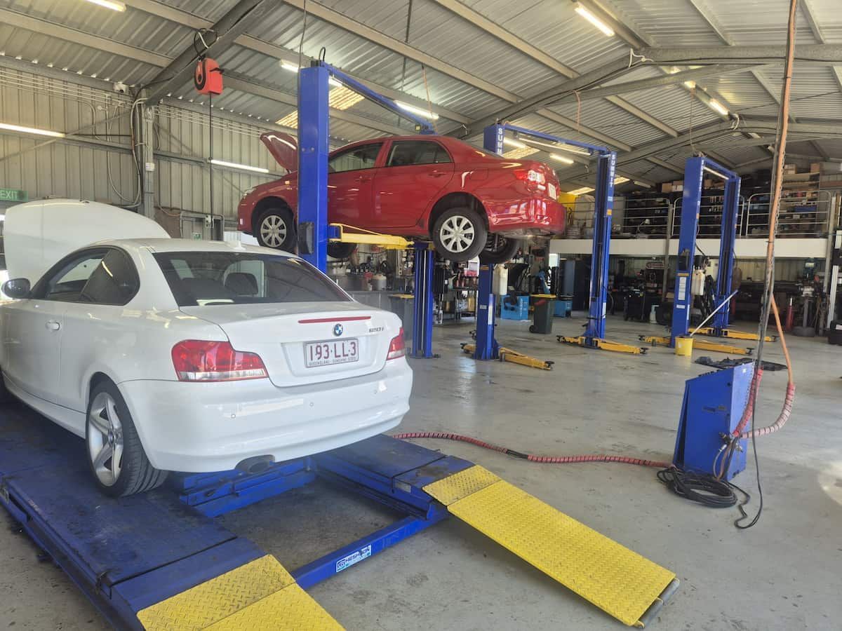 Auto Repair Shop With Two Cars on Hydraulic Lifts — Emu Park Automotive and Tyre Service in Lammermoor, QLD