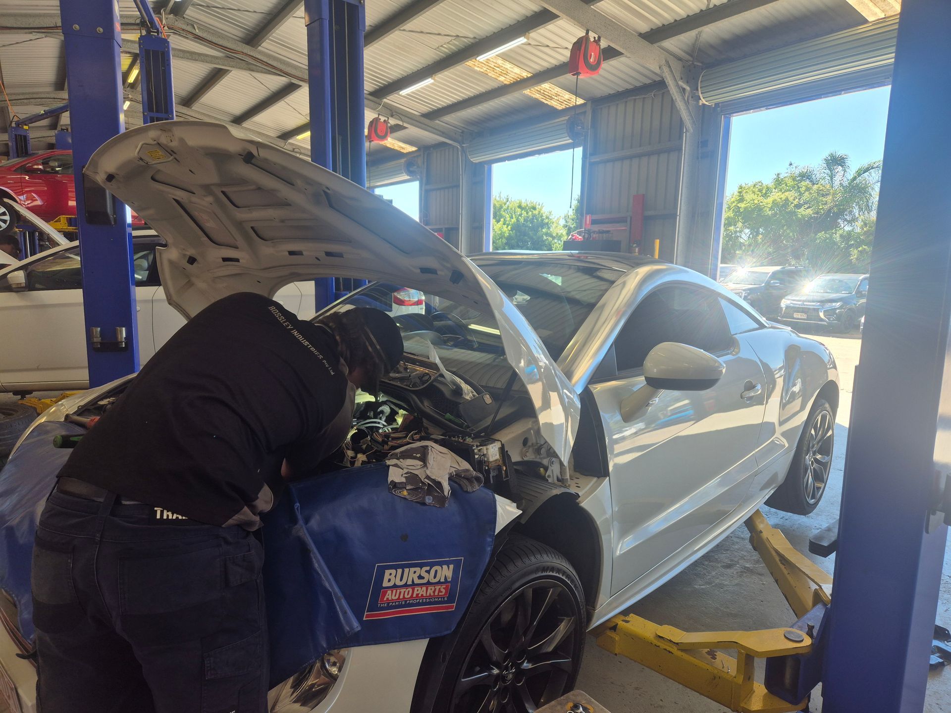 Mechanic Working Under the Hood of a White Car in an Auto Repair Shop — Emu Park Automotive and Tyre Service in Emu Park, QLD