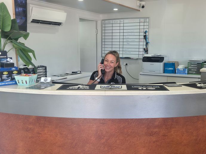 Reception Desk With a Smiling Woman on the Phone — Emu Park Automotive and Tyre Service in Emu Park, QLD