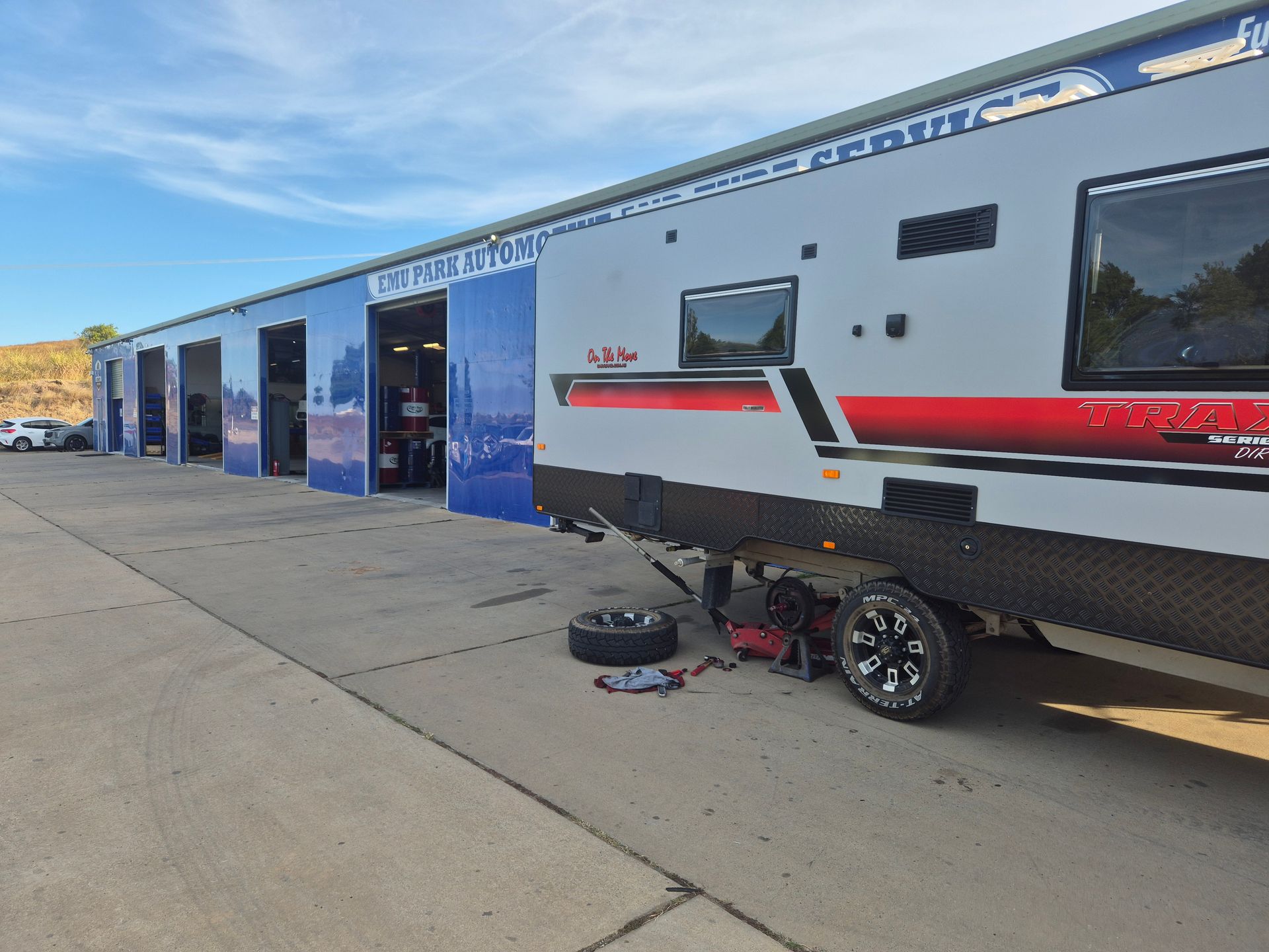 RV parked outside a service bay with its front wheel removed and tools on the ground — Emu Park Automotive and Tyre Service in Emu Park, QLD