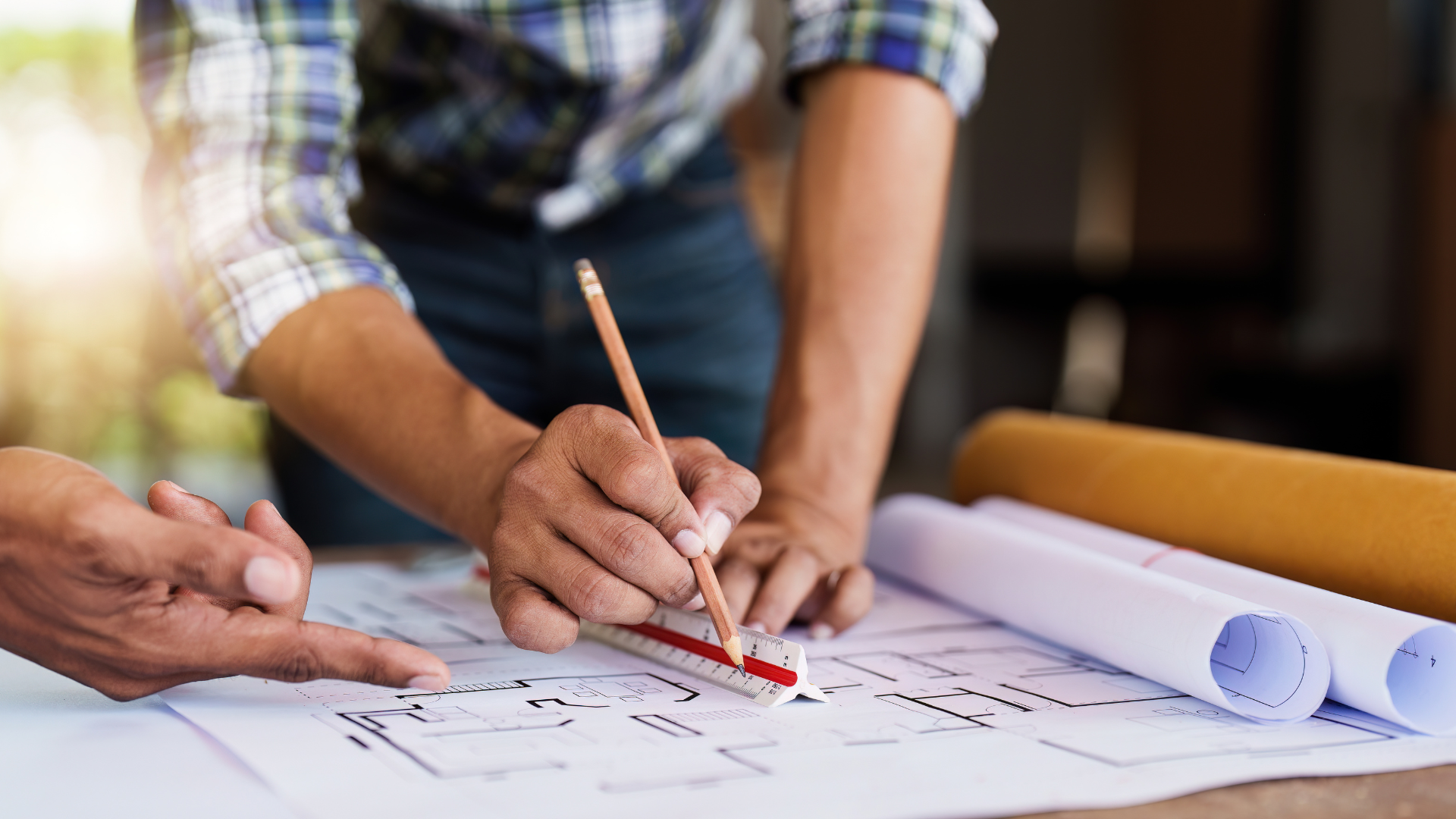 A group of people are working on a blueprint on a table.
