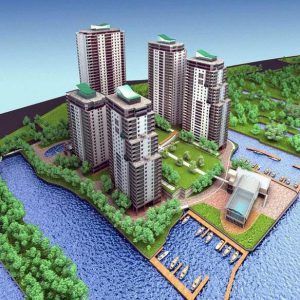 A model of a city with a lot of tall buildings surrounded by water and trees.