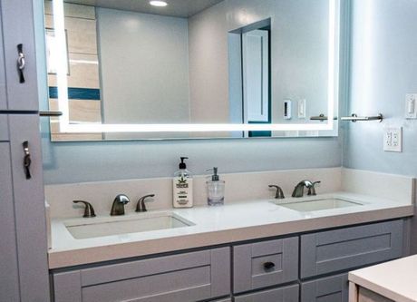 Modern bathroom vanity with double sinks, large mirror, and light gray cabinets