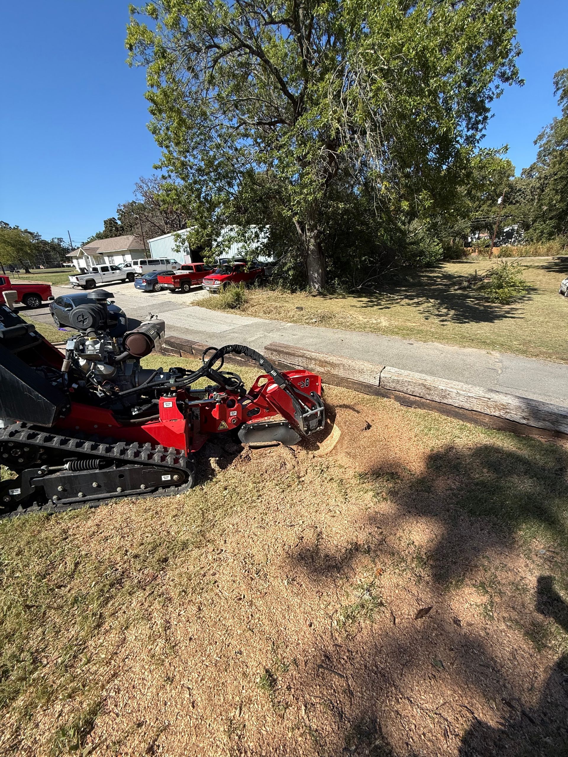 A man is using a stump grinder to remove a tree stump.