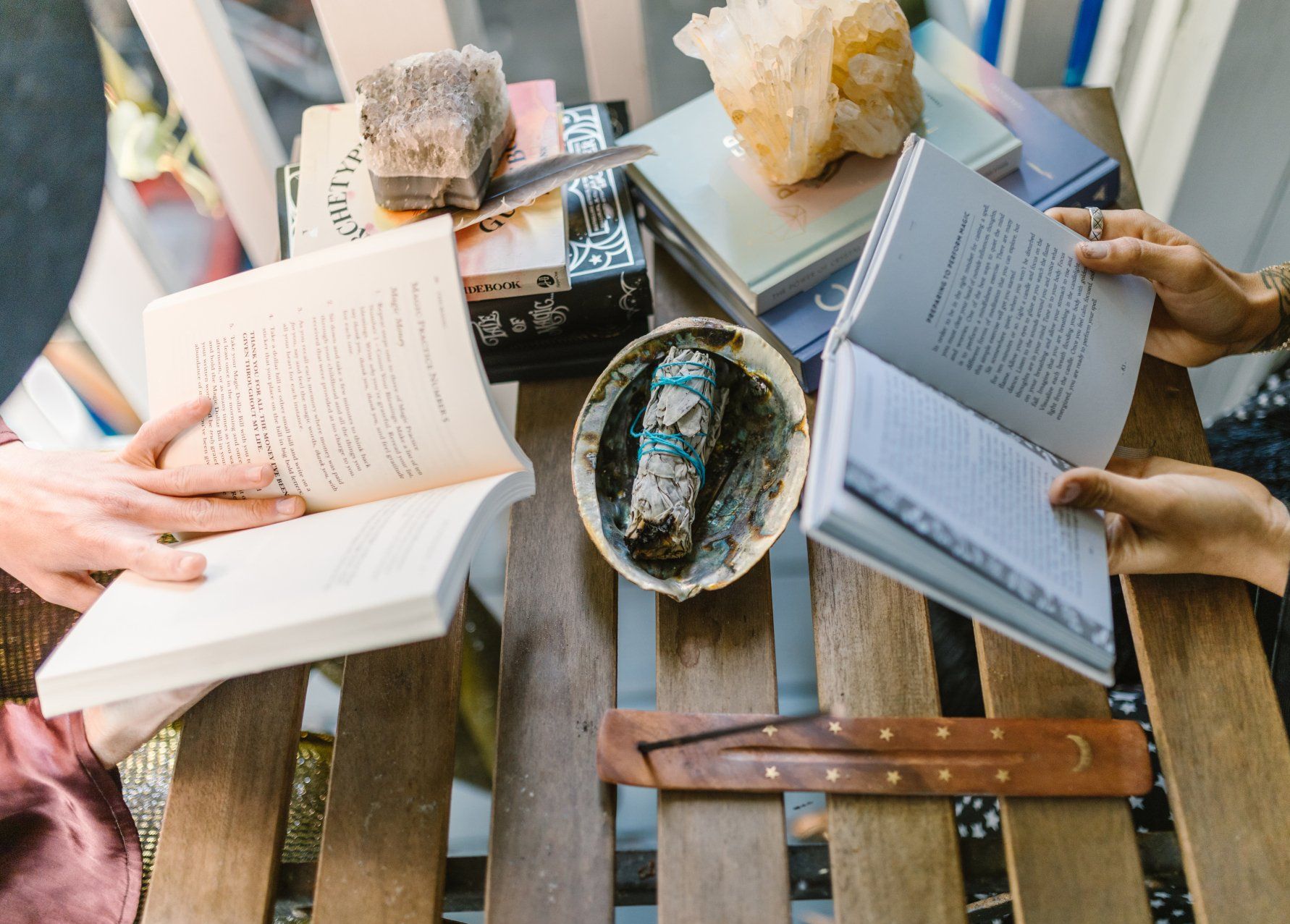 A group of people are sitting at a table reading books.