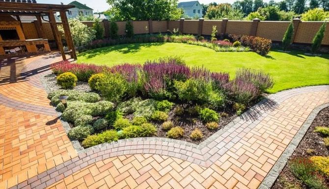 Herringbone paver patio and walkway beside a planting bed and pergola