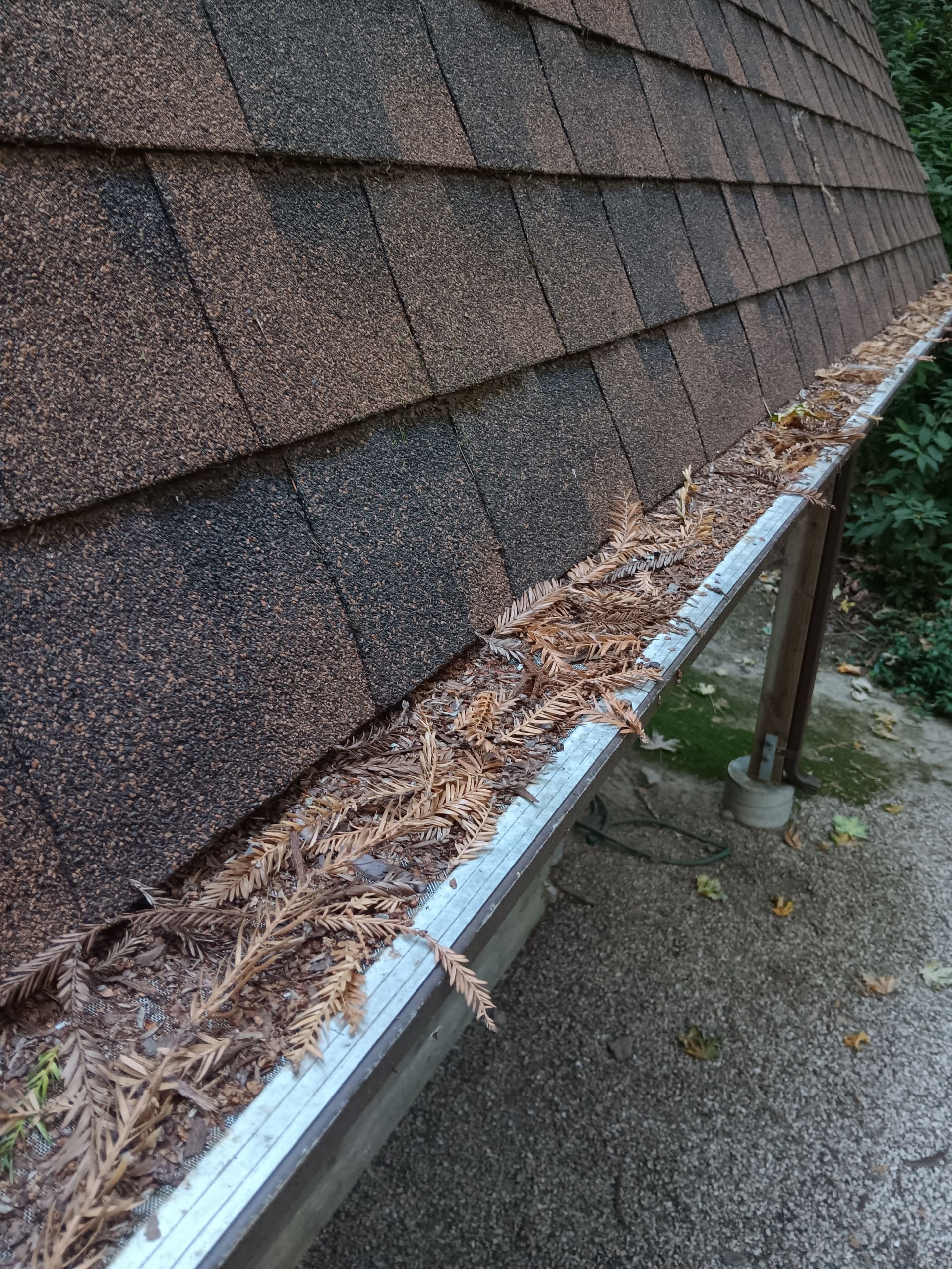 Rusty metal gutter bracket on weathered wooden wall with peeling paint