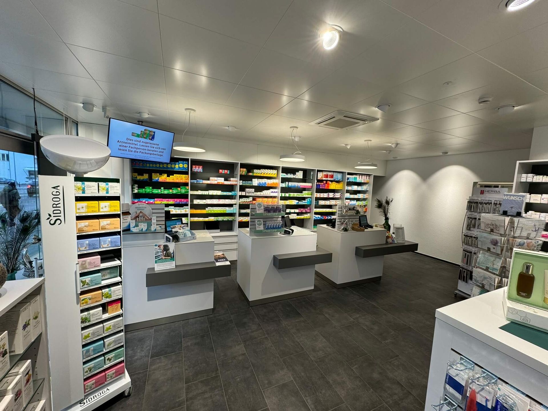 Das Innere einer Apotheke mit vielen Regalen und Theken.