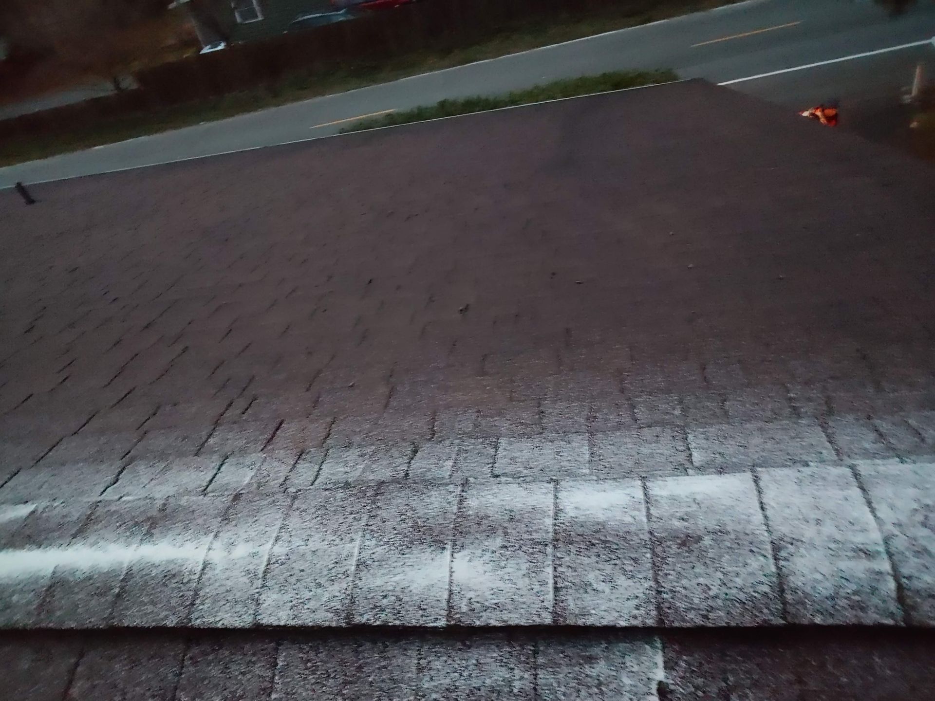 A roof with a lot of shingles and a road in the background