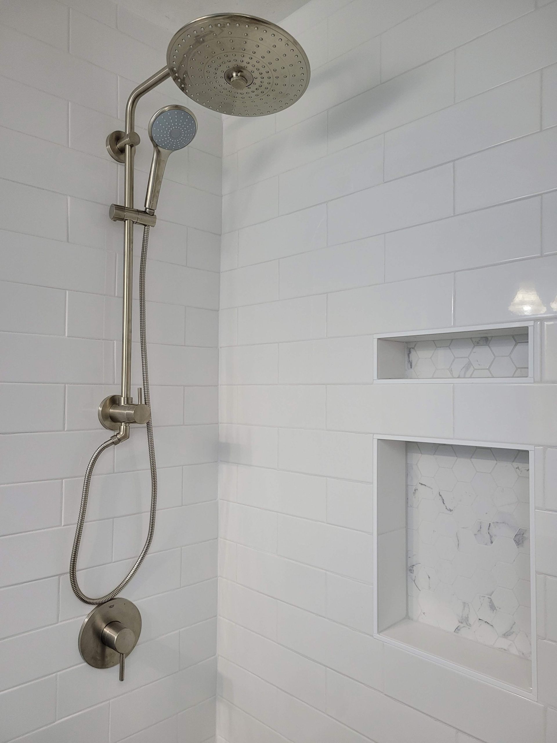 There is a shower head in the corner of the shower.