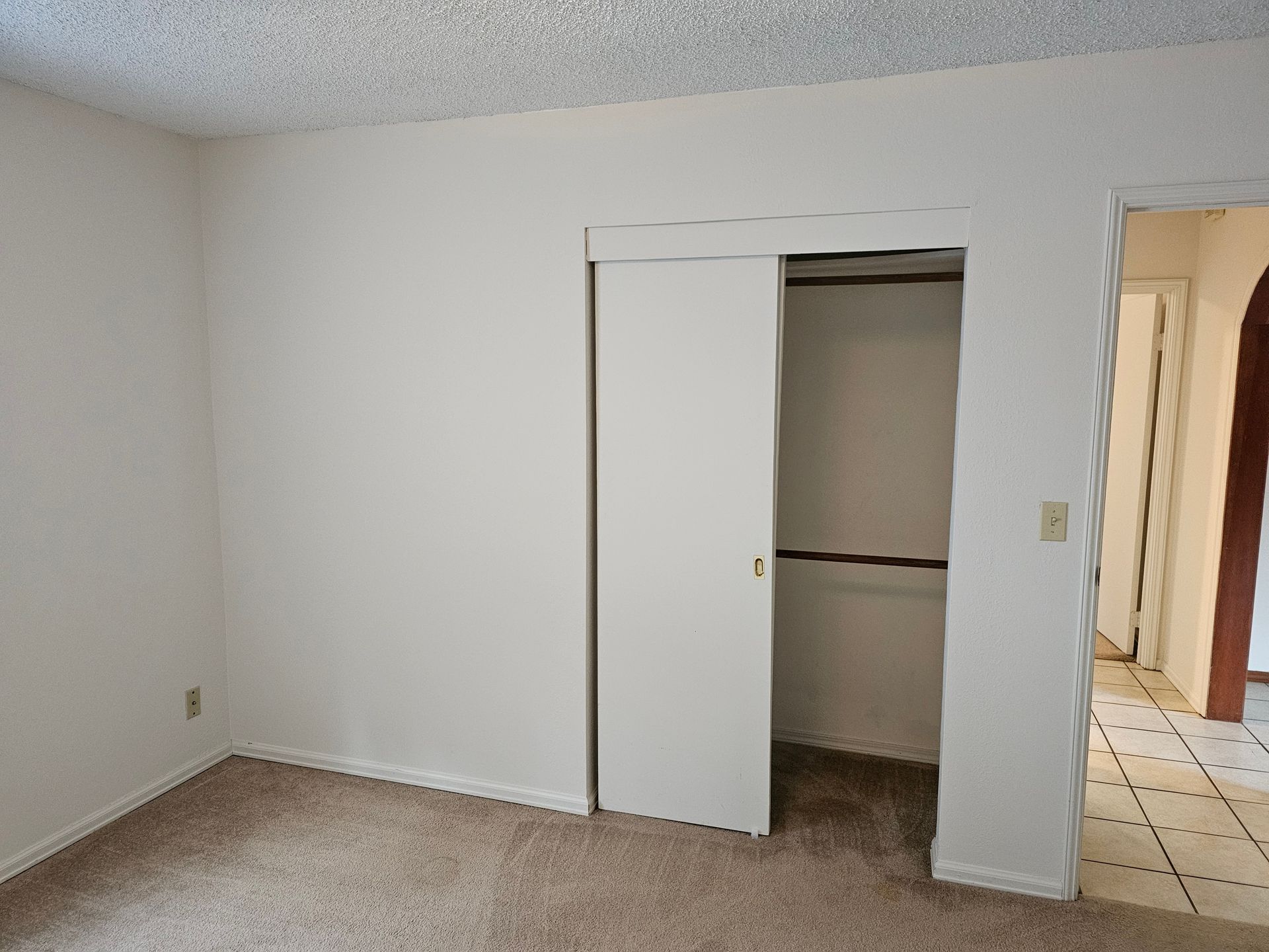 An empty bedroom with a closet in the corner.