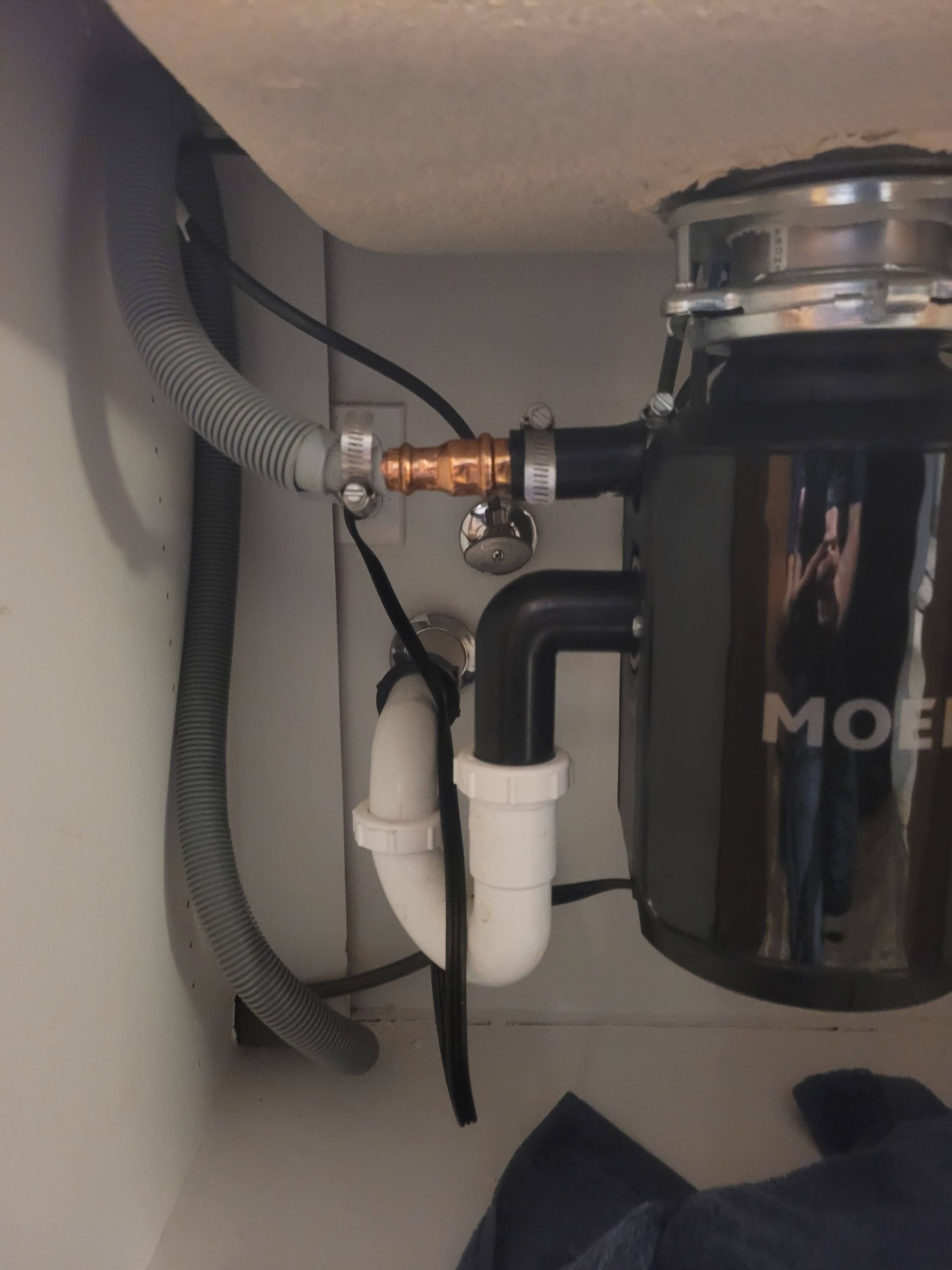 A black moet garbage disposal is under a sink