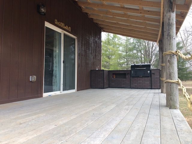 A porch with a grill and a sliding glass door