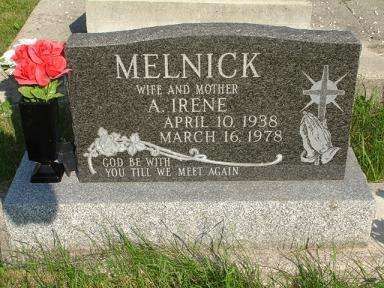 Gravestone for Melnick and Irene with a red flower in a vase on the left side.