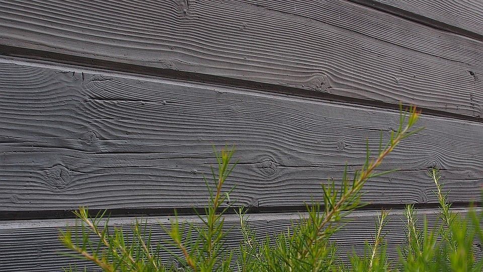 Grey Wood Siding With Visible Grain, Green Sprigs in Foreground — Concrete Sleepers NSW - Port Macquarie in Sancrox, NSW