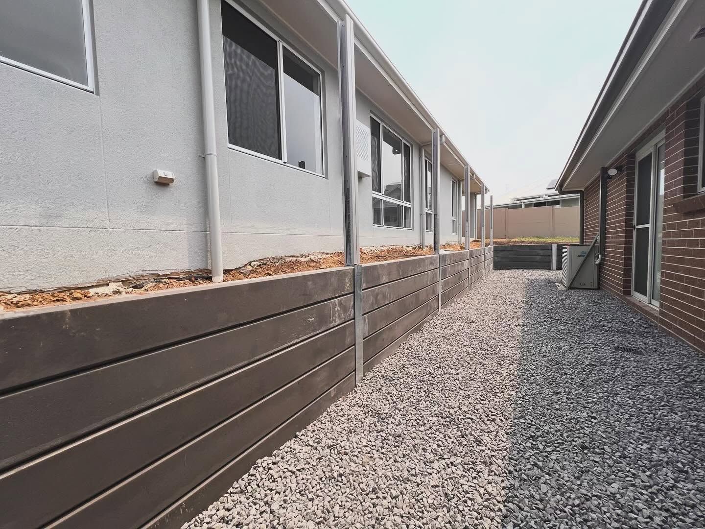 Narrow Gravel Side Yard Between Gray Stucco — Concrete Sleepers NSW - Port Macquarie in Central Coast, NSW