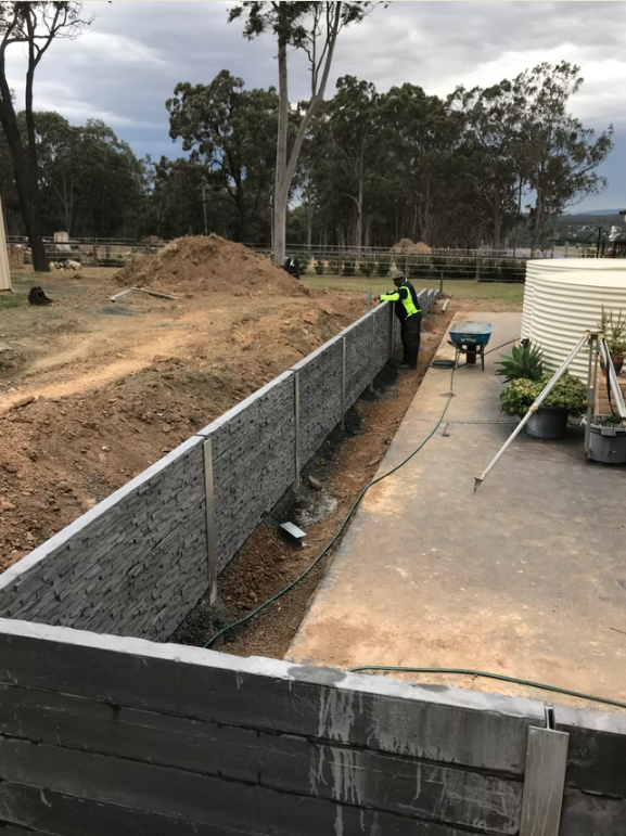 Construction Site: Worker Near a Long Concrete Wall — Concrete Sleepers NSW - Port Macquarie in Sancrox, NSW