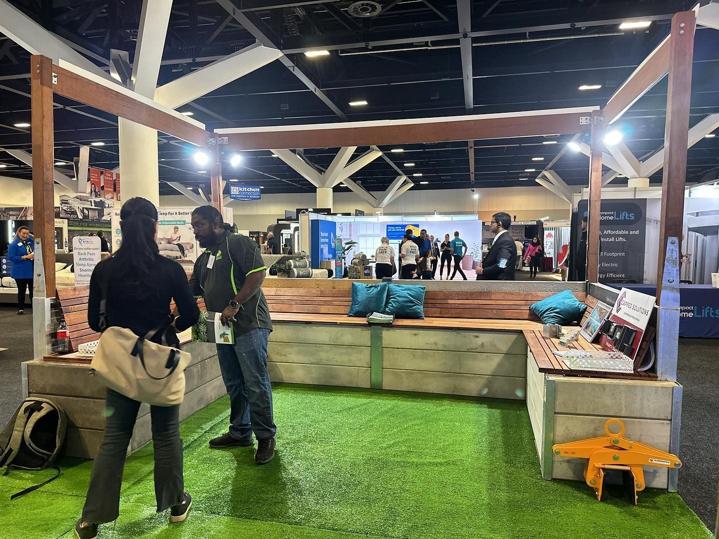 Trade Show Booth With Faux Grass, People, and Wood Seating — Concrete Sleepers NSW - Port Macquarie in Singleton, NSW