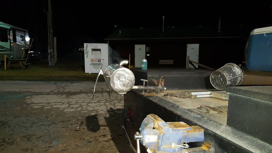 Dim outdoor industrial area with equipment on a platform and a lit truck in the background at night