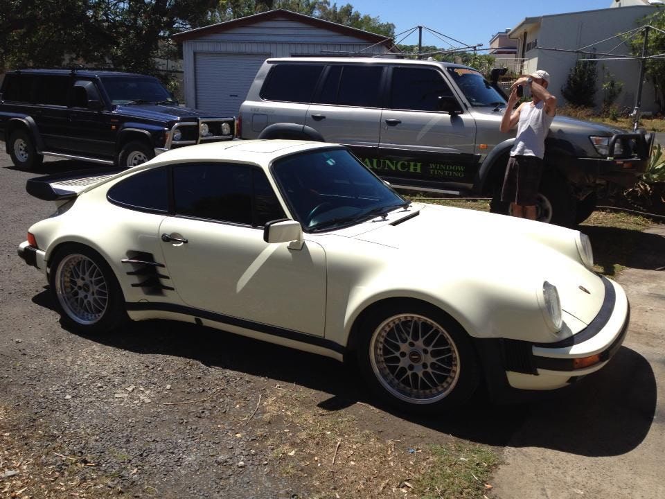 A White Porsche Is Parked Next To A Black SUV — Staunch Window Tinting In South Lismore, NSW