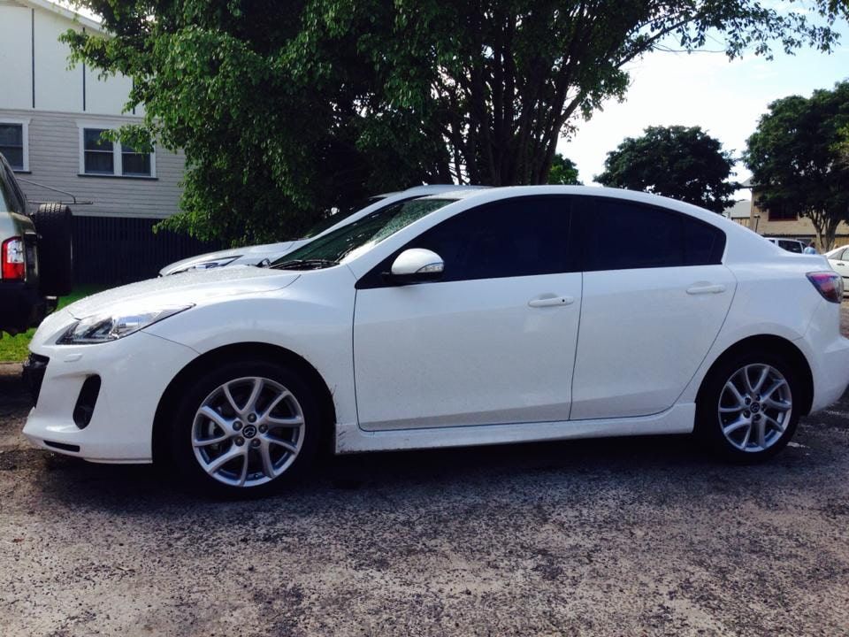 A White Car With Tint Window Is Parked In A Gravel Lot — Staunch Window Tinting In South Lismore, NSW