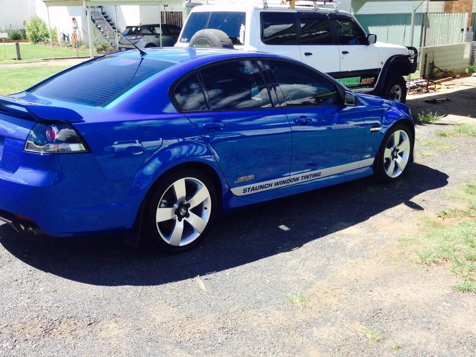 A Blue Car Is Parked On The Side Of The Road — Staunch Window Tinting In South Lismore, NSW