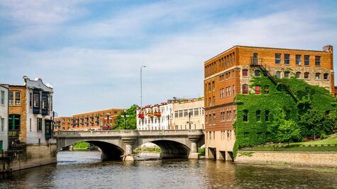 A bridge over a river with a building in the background.