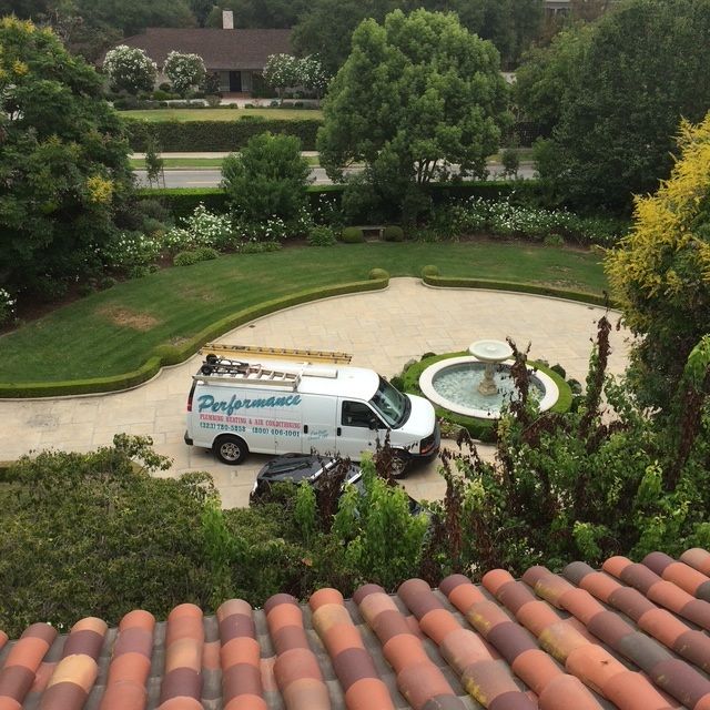 White service van by a circular fountain in a landscaped driveway, viewed from above