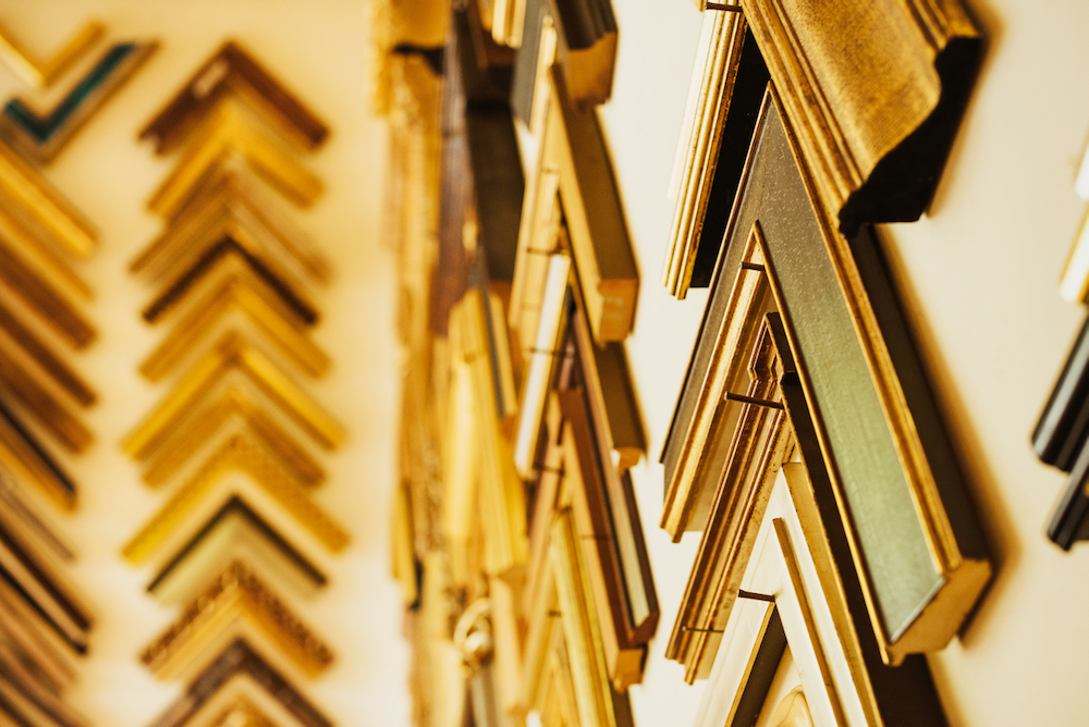 A bunch of picture frames are hanging on a wall.