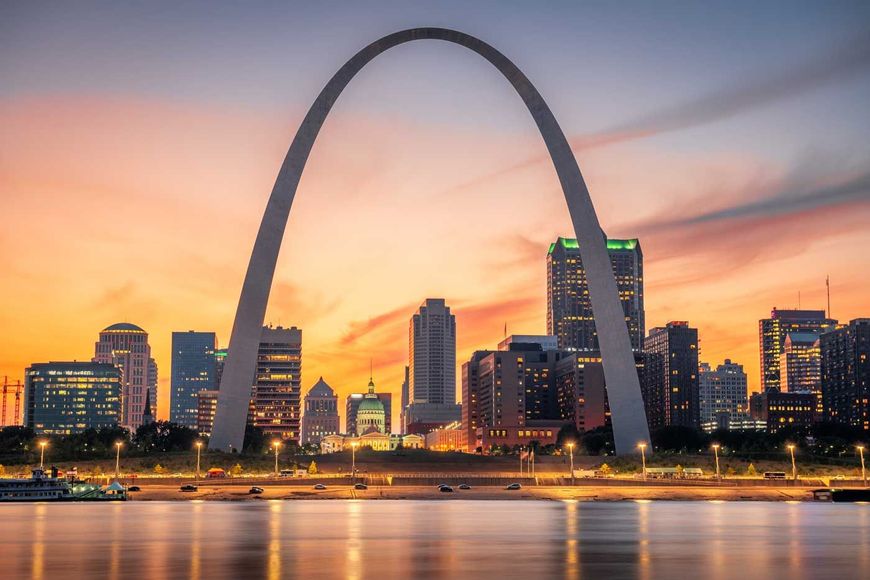 A city skyline with the st. louis arch in the foreground