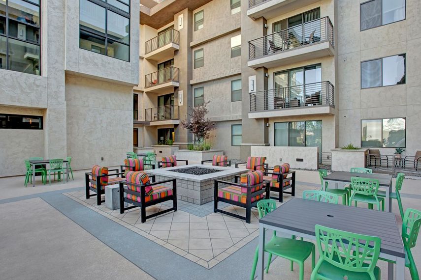 There is a fire pit in the middle of the courtyard of a building.