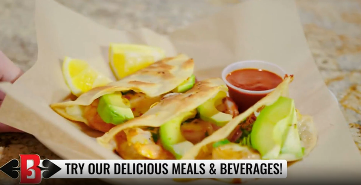 Wraps, fries, lemon wedges, and dipping sauce on a tray with “Try our delicious meals & beverages” banner